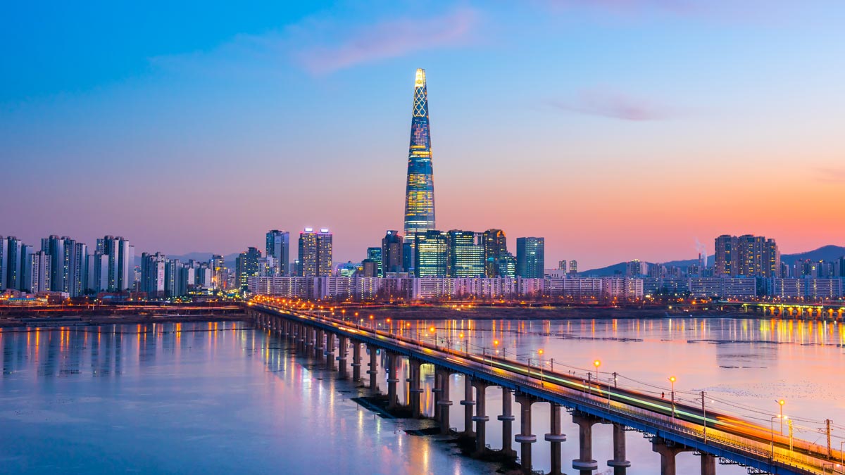 a bridge over water with a city in the background