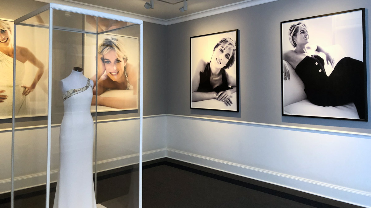 a mannequin in a white dress in a room with pictures on the wall