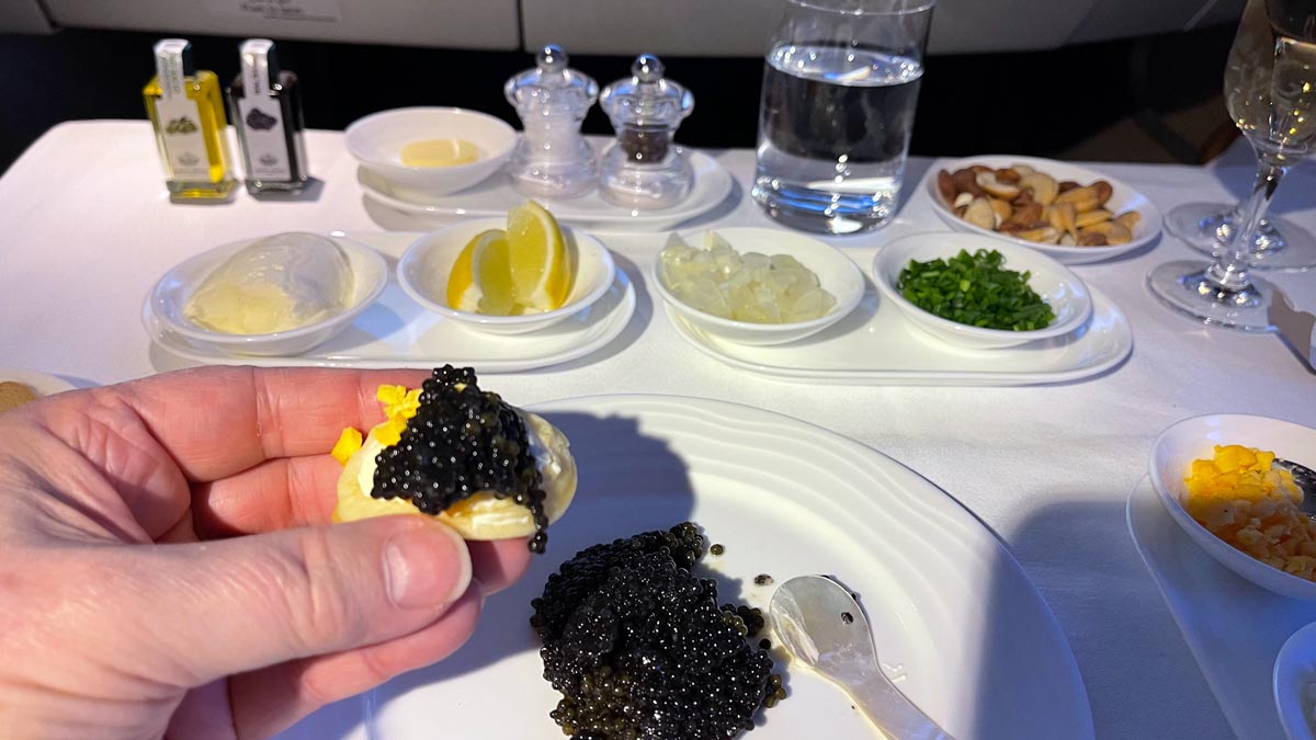 a hand holding a black caviar on a plate