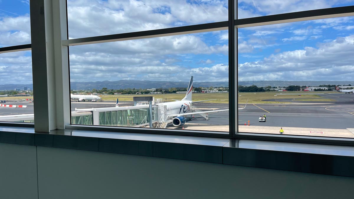 a window with a plane on the runway