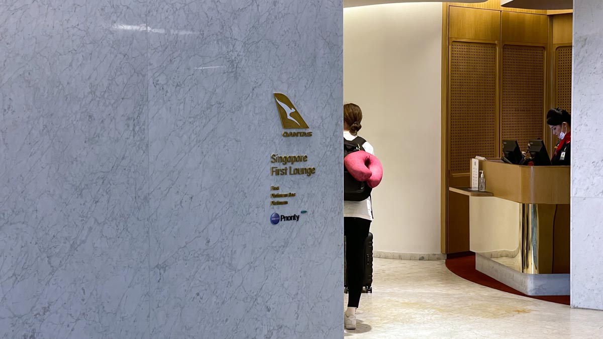 a woman with a pink pillow in her back standing in a lobby