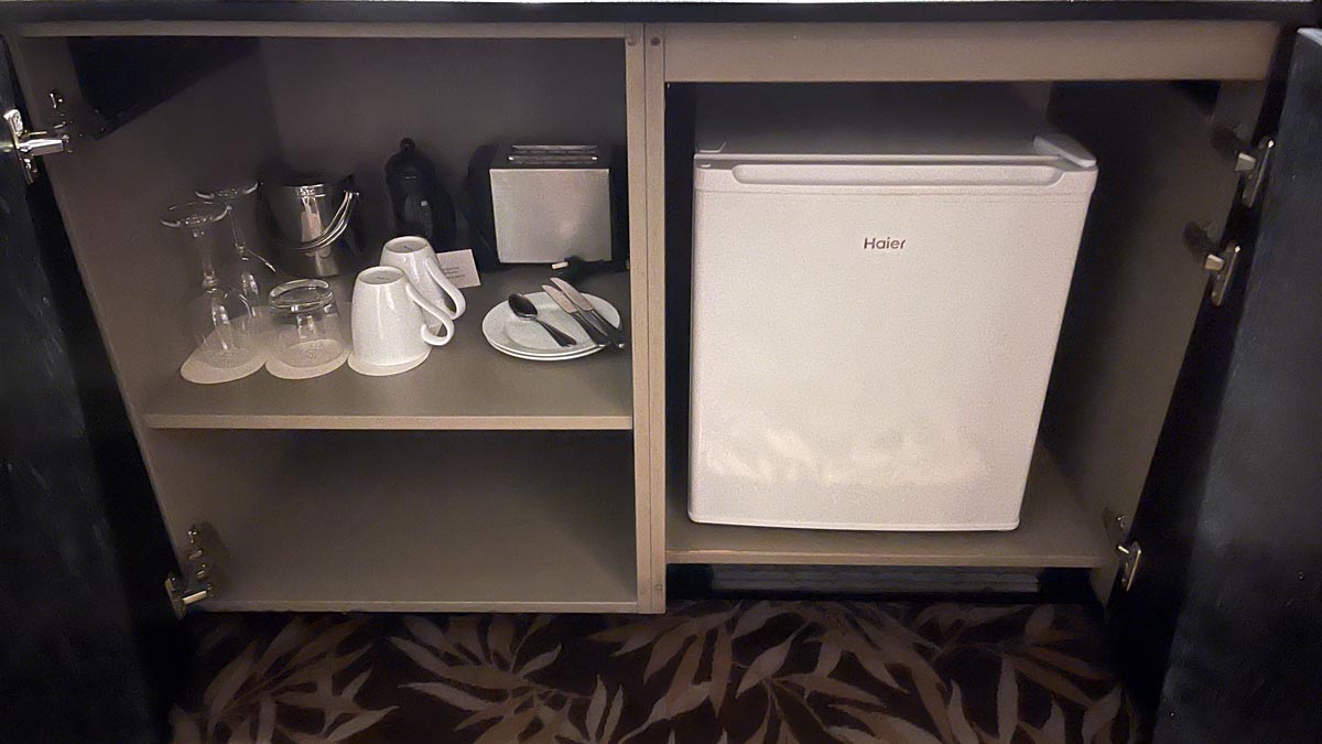 a small refrigerator and utensils on a shelf