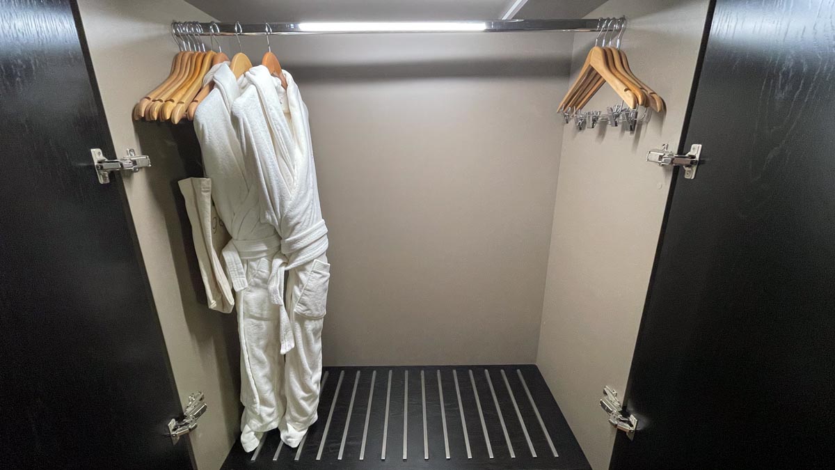 a white robe on swingers in a closet