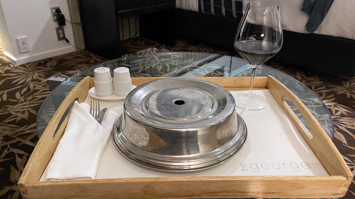 a tray with a silver bowl and a glass of wine