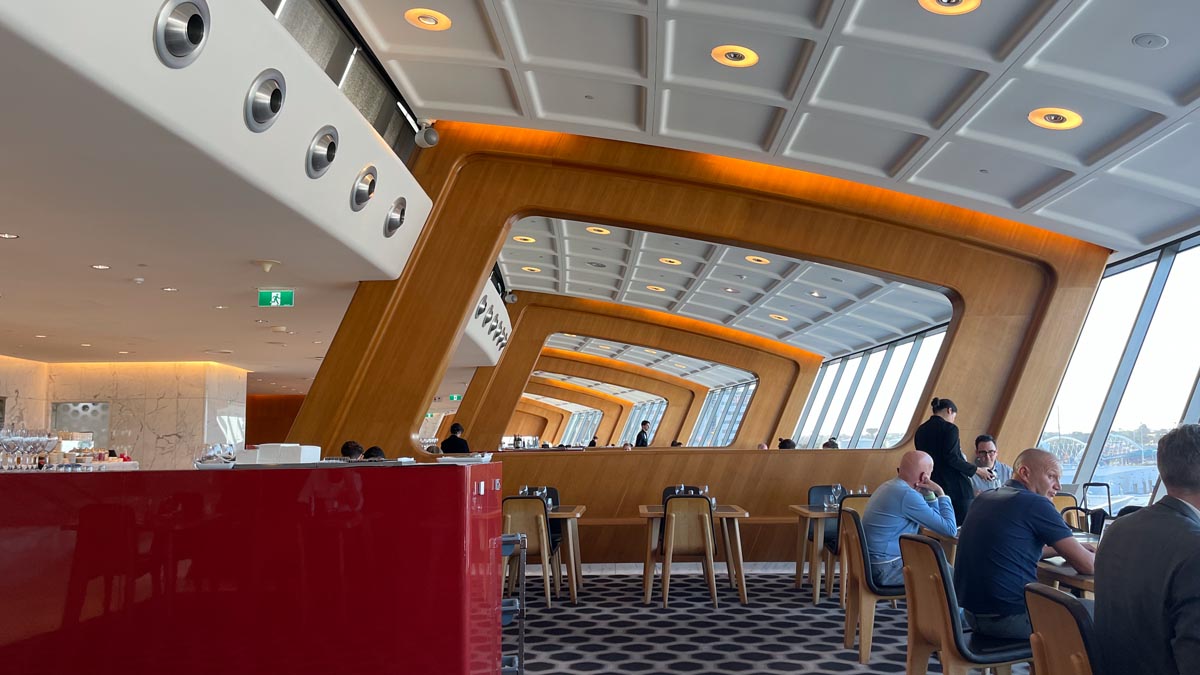 a room with a red counter and tables and chairs