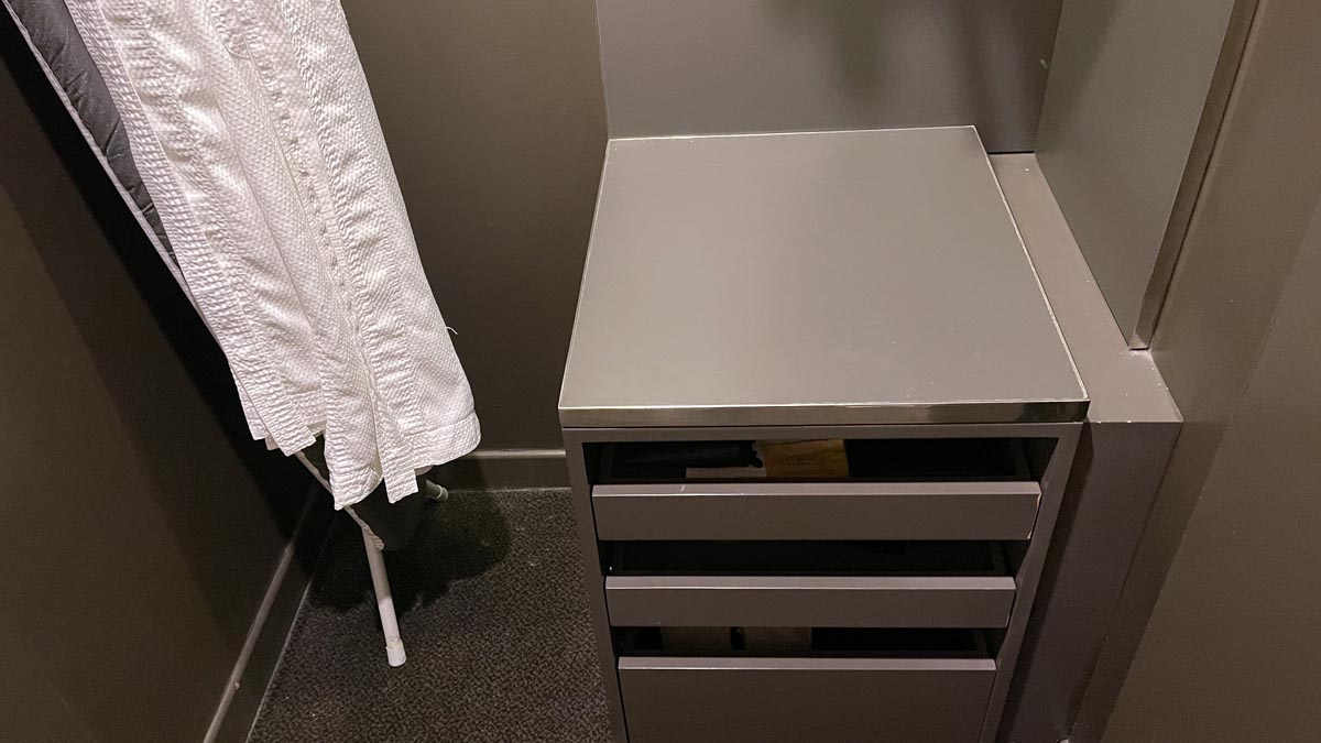 a white towel on a rack next to a grey table