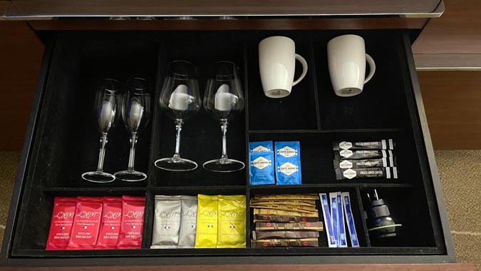 a drawer with wine glasses and other items