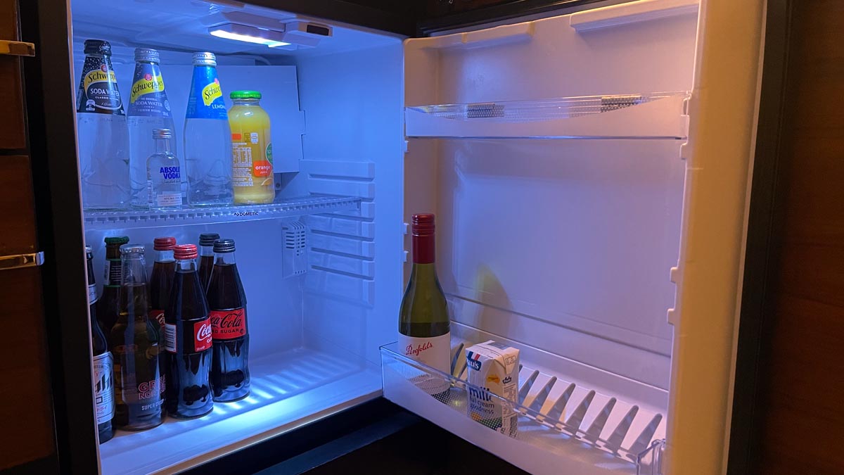 a refrigerator with bottles of soda and milk