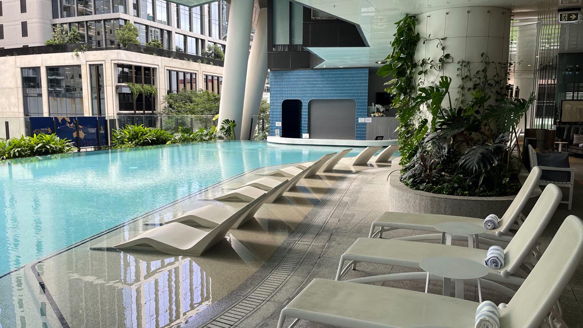 a pool with lounge chairs and a building