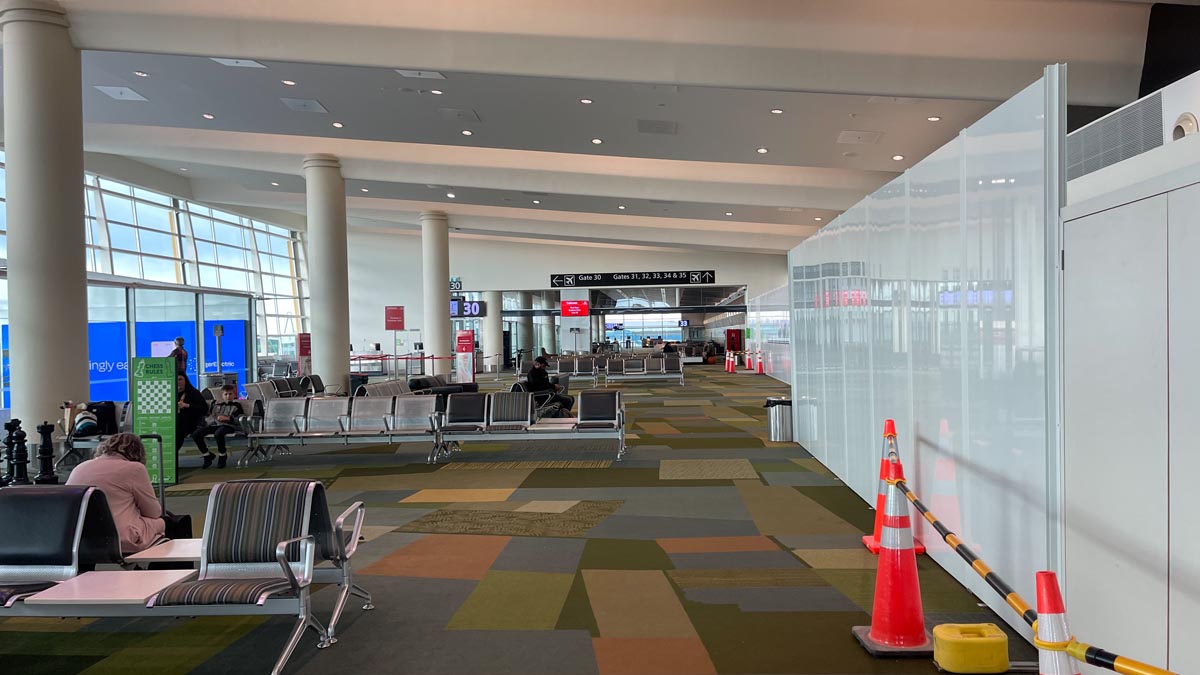 an airport with chairs and orange cones