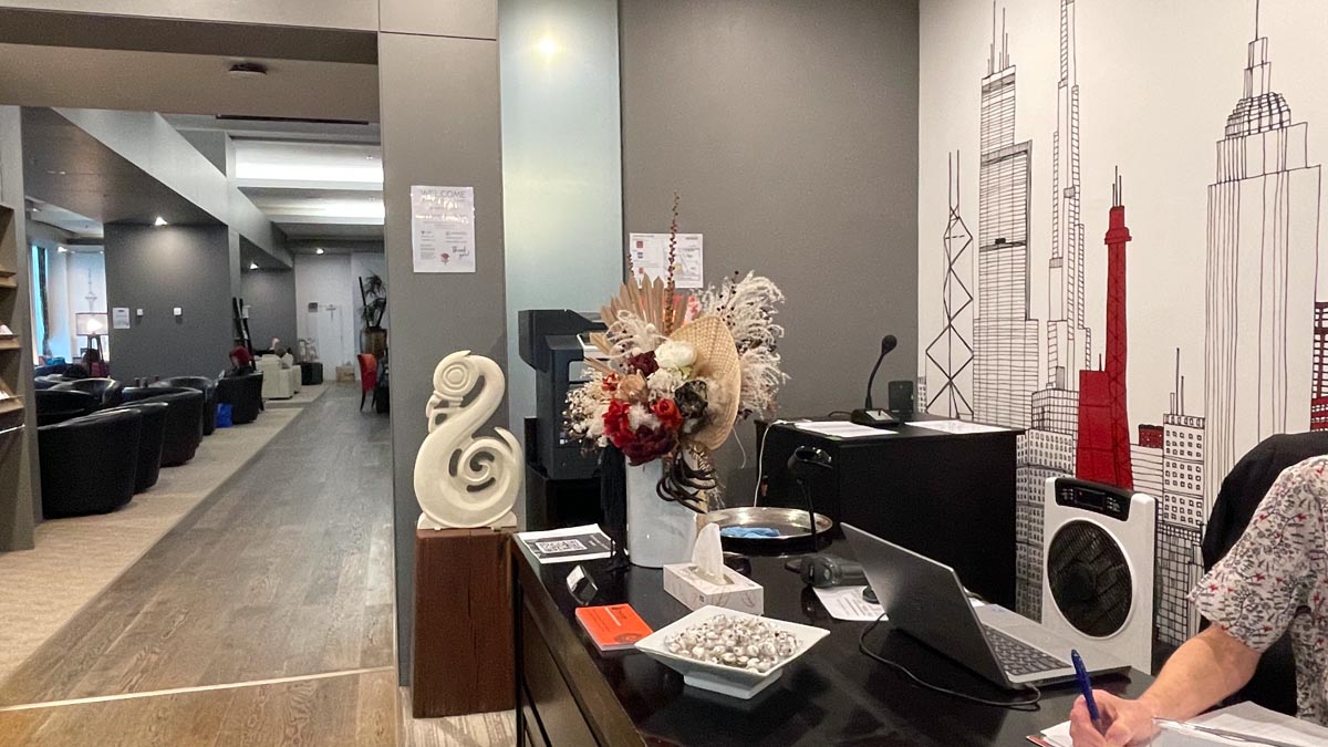 a desk with a laptop and a vase of flowers