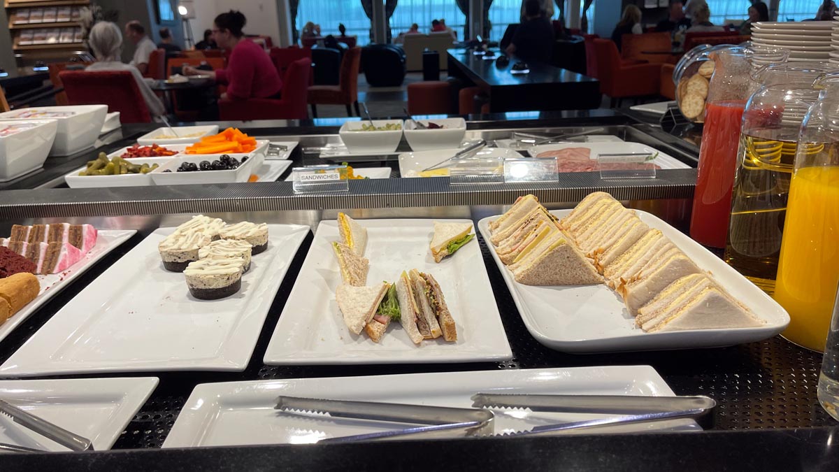 a buffet table with plates of sandwiches and fruit