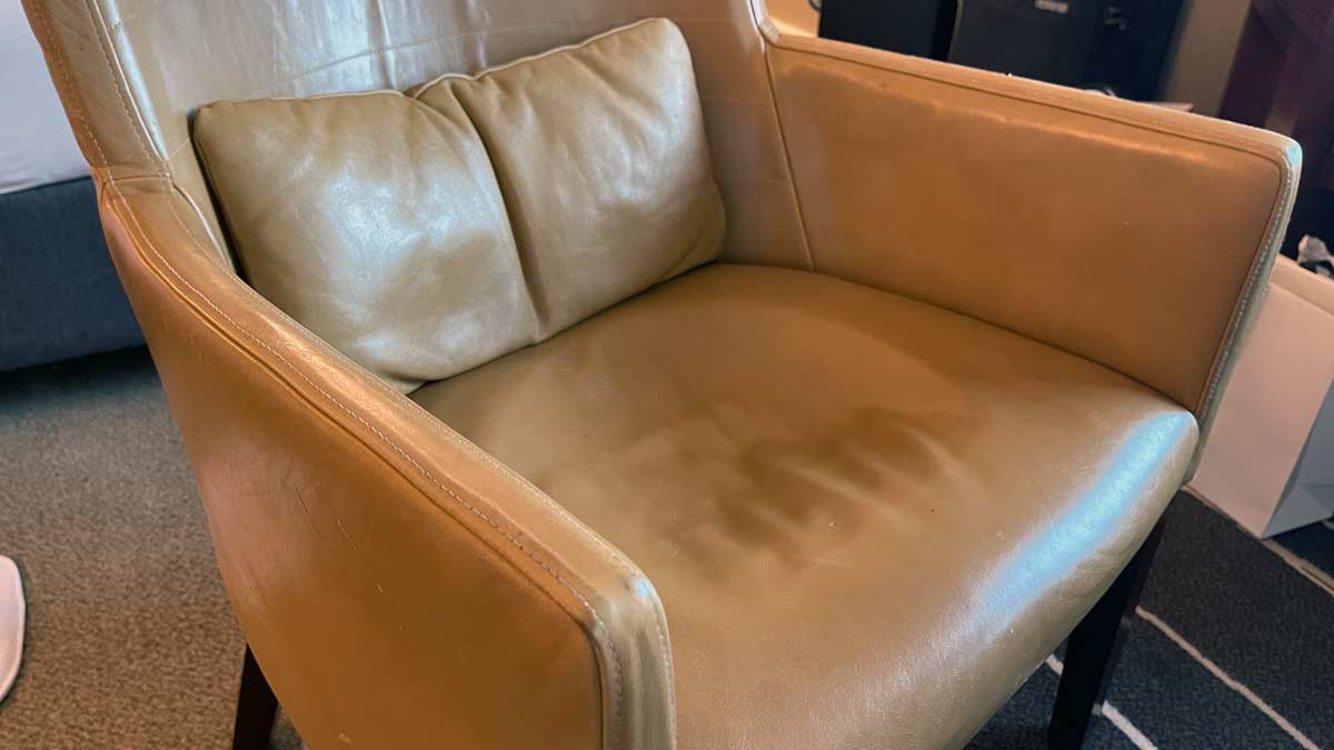 a tan leather chair with a pillow