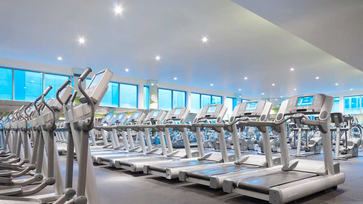 a room with treadmills and a row of machines