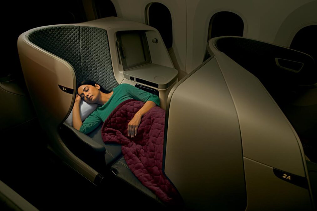 a woman sleeping in a seat on an airplane