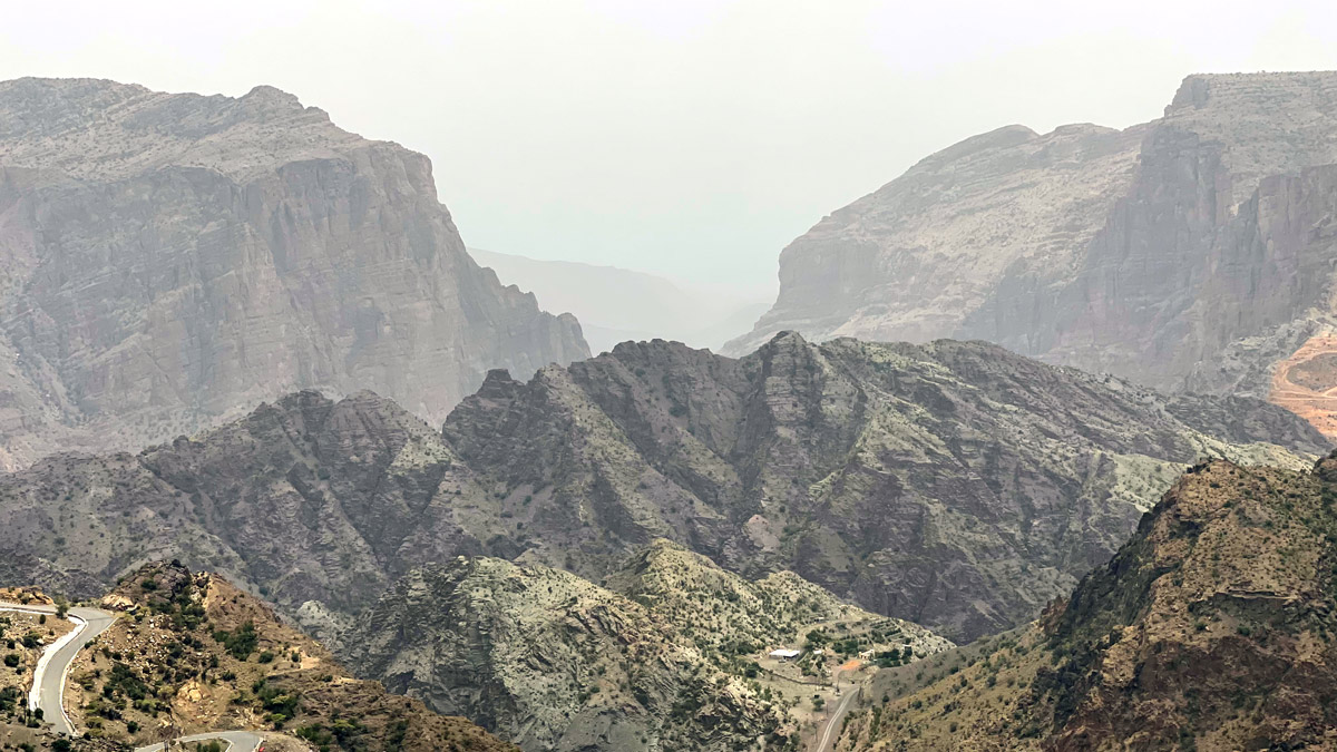 a mountain range with a road and trees