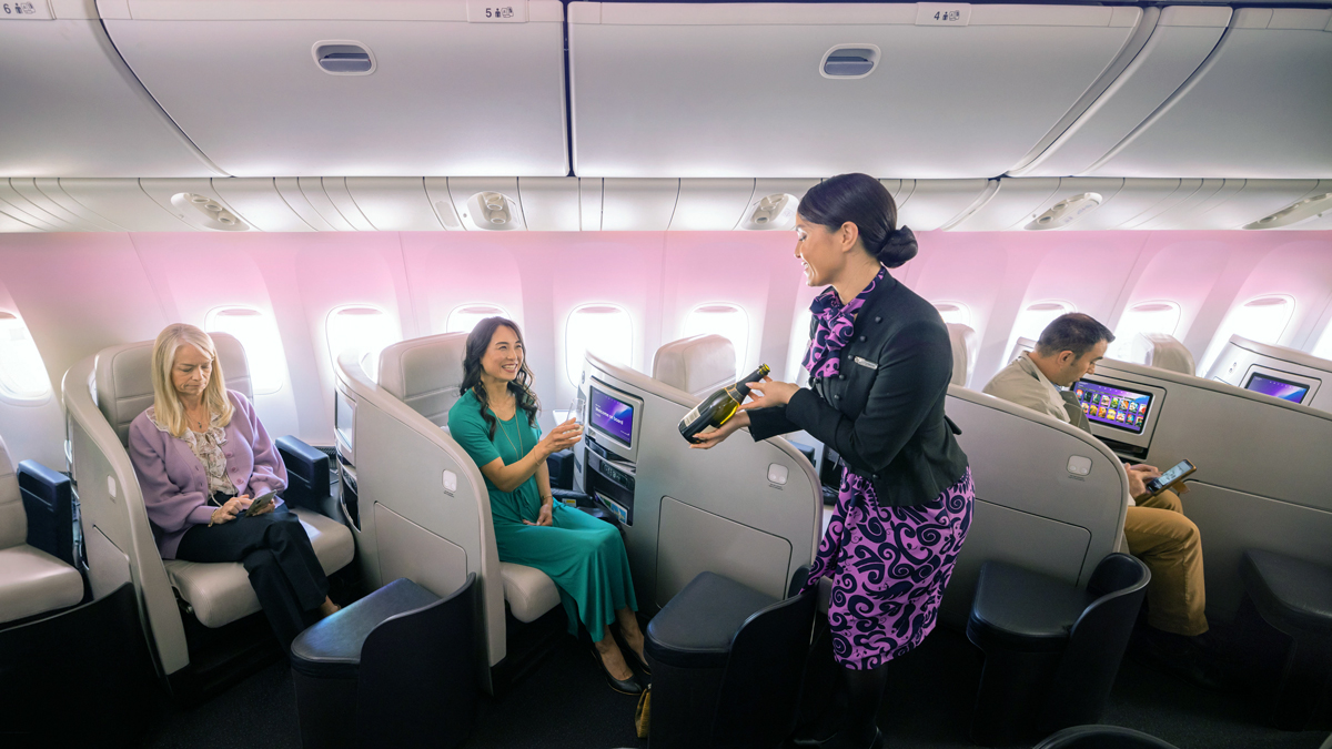 a woman holding a bottle of champagne in a plane