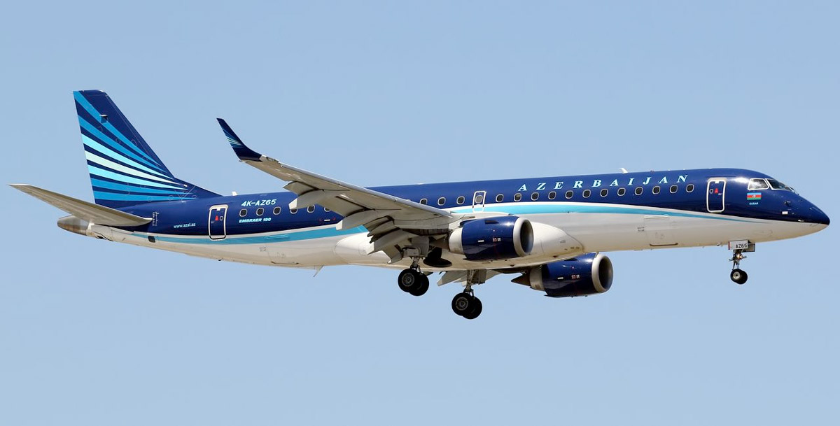 a blue and white airplane flying in the sky