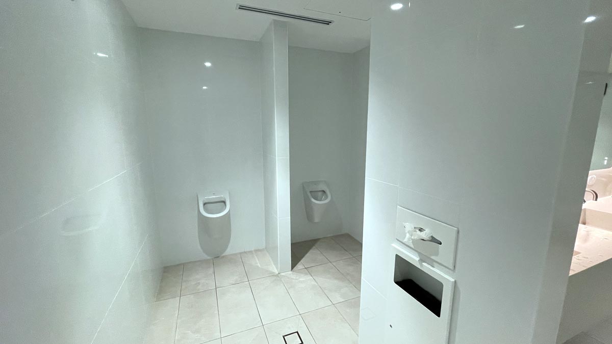 a bathroom with urinals and a white tile floor