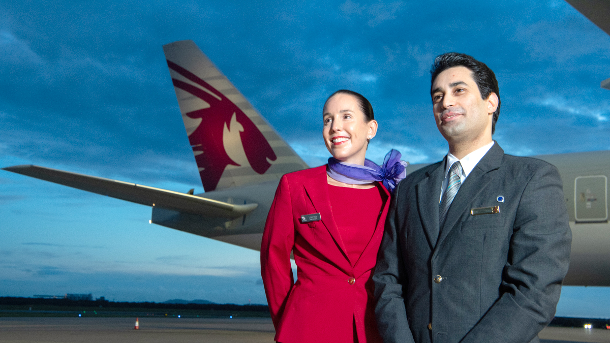 a man and woman standing in front of an airplane