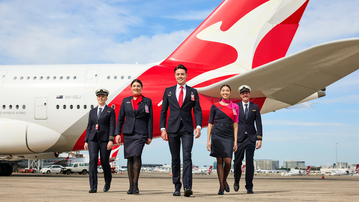 a group of people in uniform walking in front of a plane