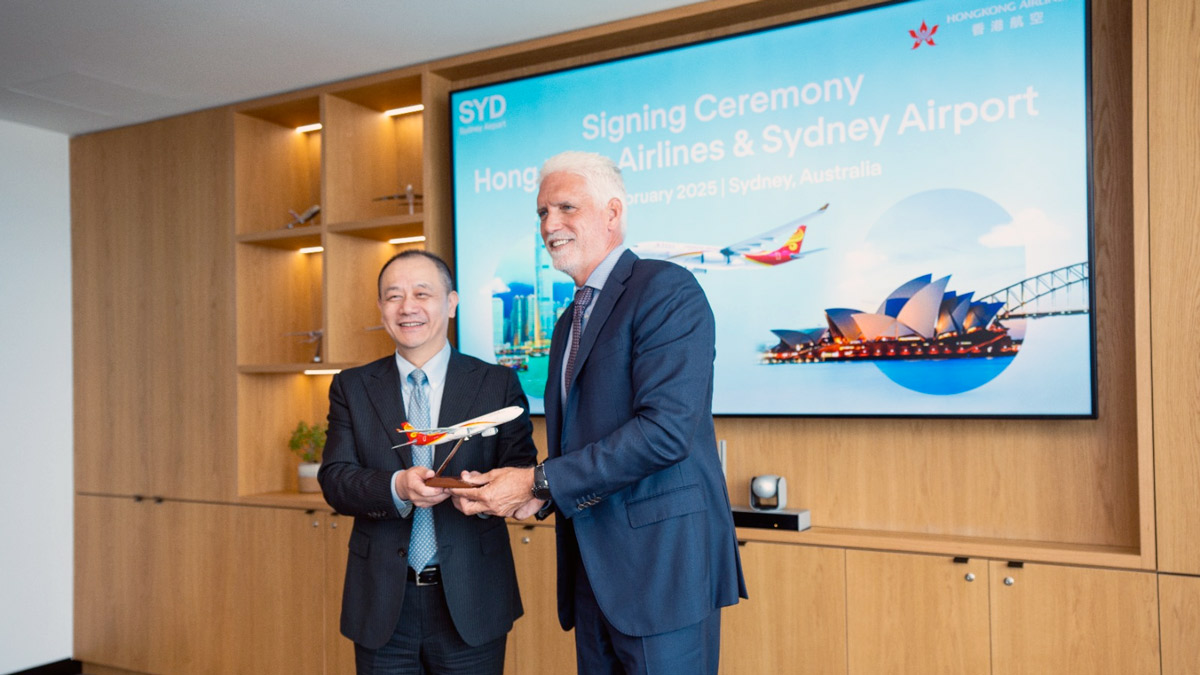 two men in suits holding a model airplane